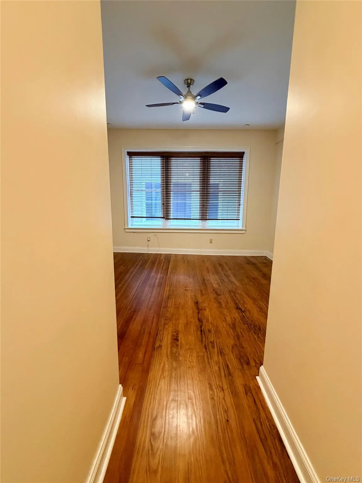 Unfurnished room featuring hardwood / wood-style flooring and a ceiling fan Unfurnished room featuring hardwood / wood-style flooring and a ceiling fan