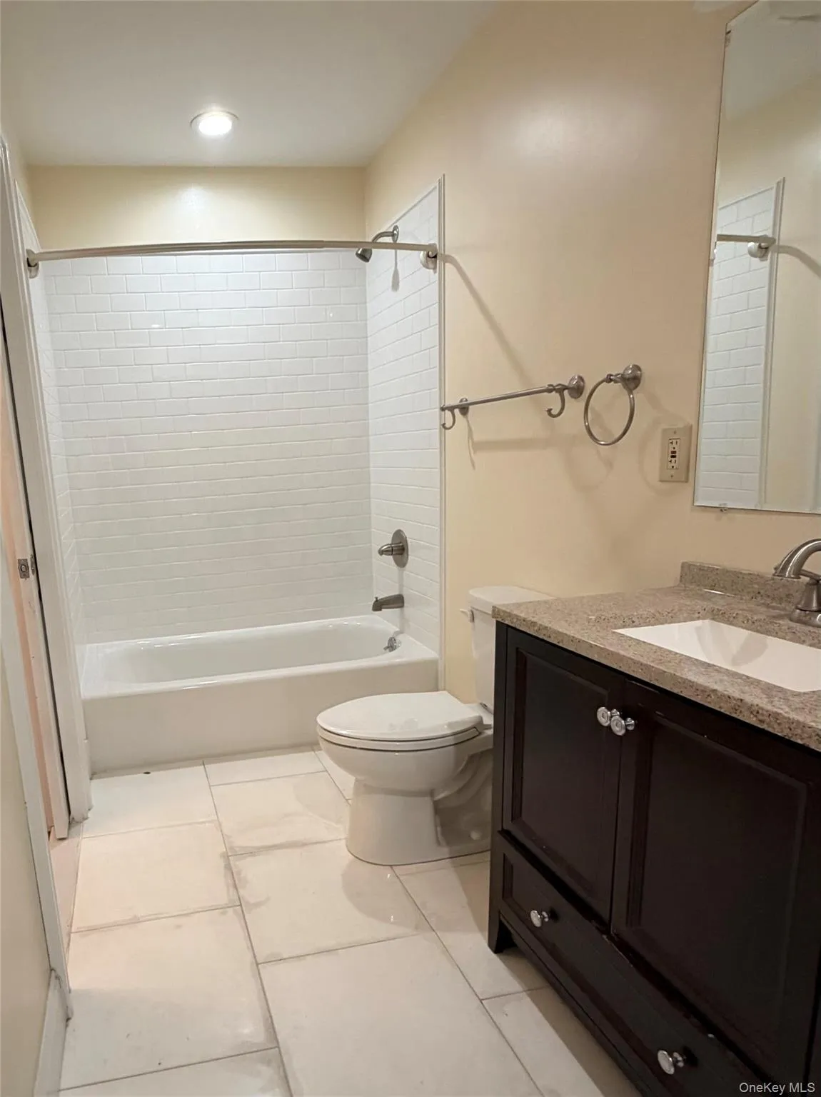 Full bathroom featuring vanity, shower / washtub combination, and light tile patterned floors Full bathroom featuring vanity, shower / washtub combination, and light tile patterned floors