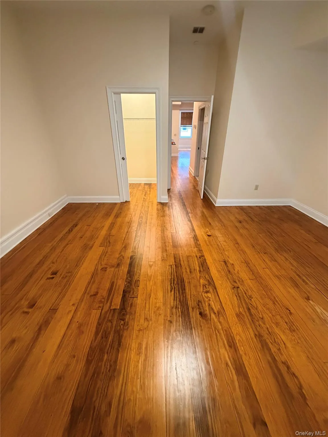Empty room with light wood finished floors and baseboards Empty room with light wood finished floors and baseboards