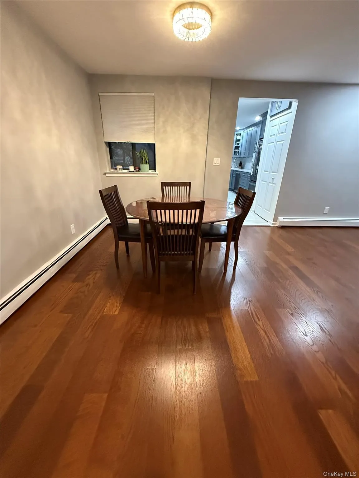 Dining area featuring a baseboard radiator and dark wood-style flooring Dining area featuring a baseboard radiator and dark wood-style flooring