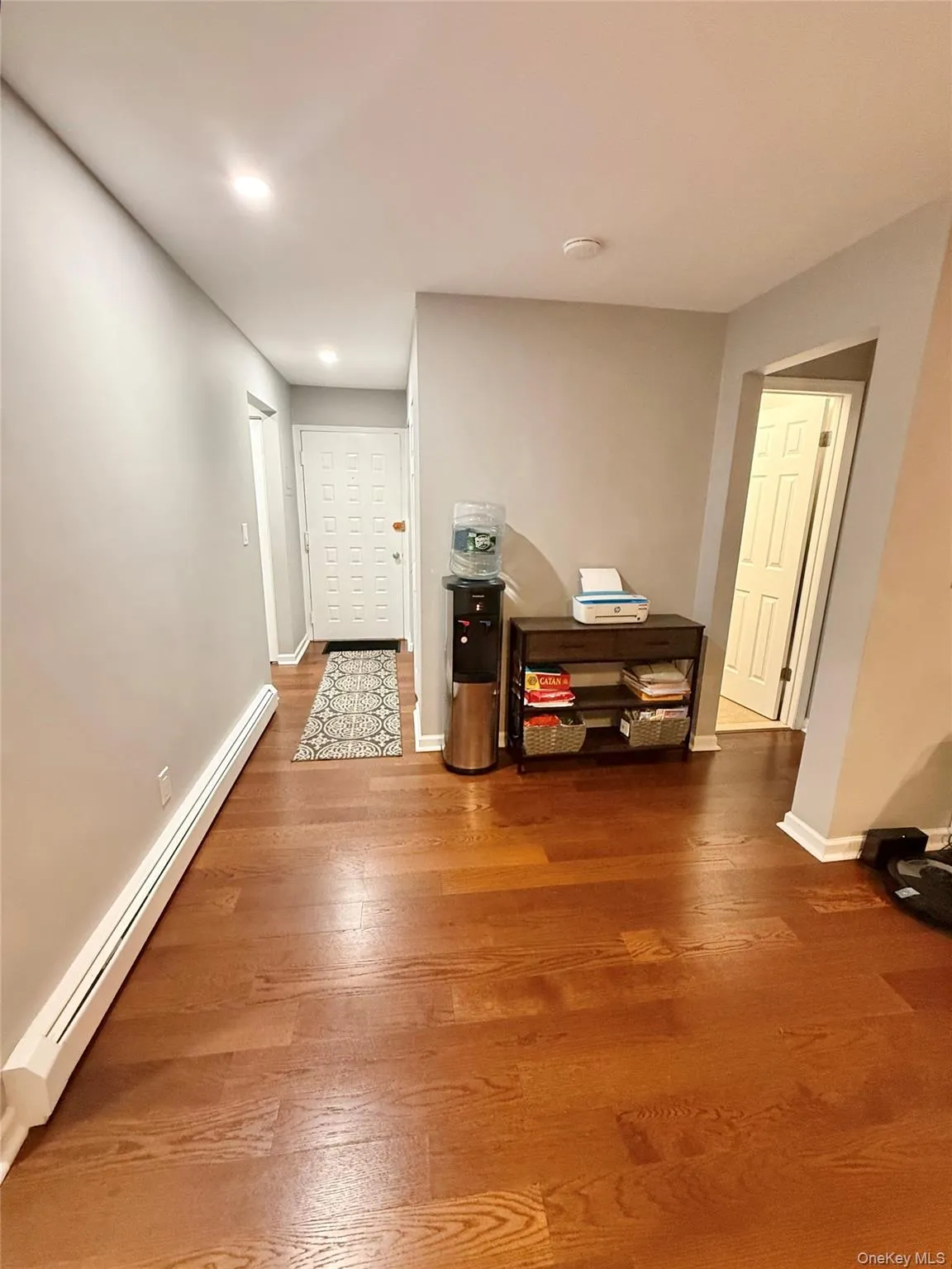 Hall featuring a baseboard radiator, wood finished floors, and recessed lighting Hall featuring a baseboard radiator, wood finished floors, and recessed lighting