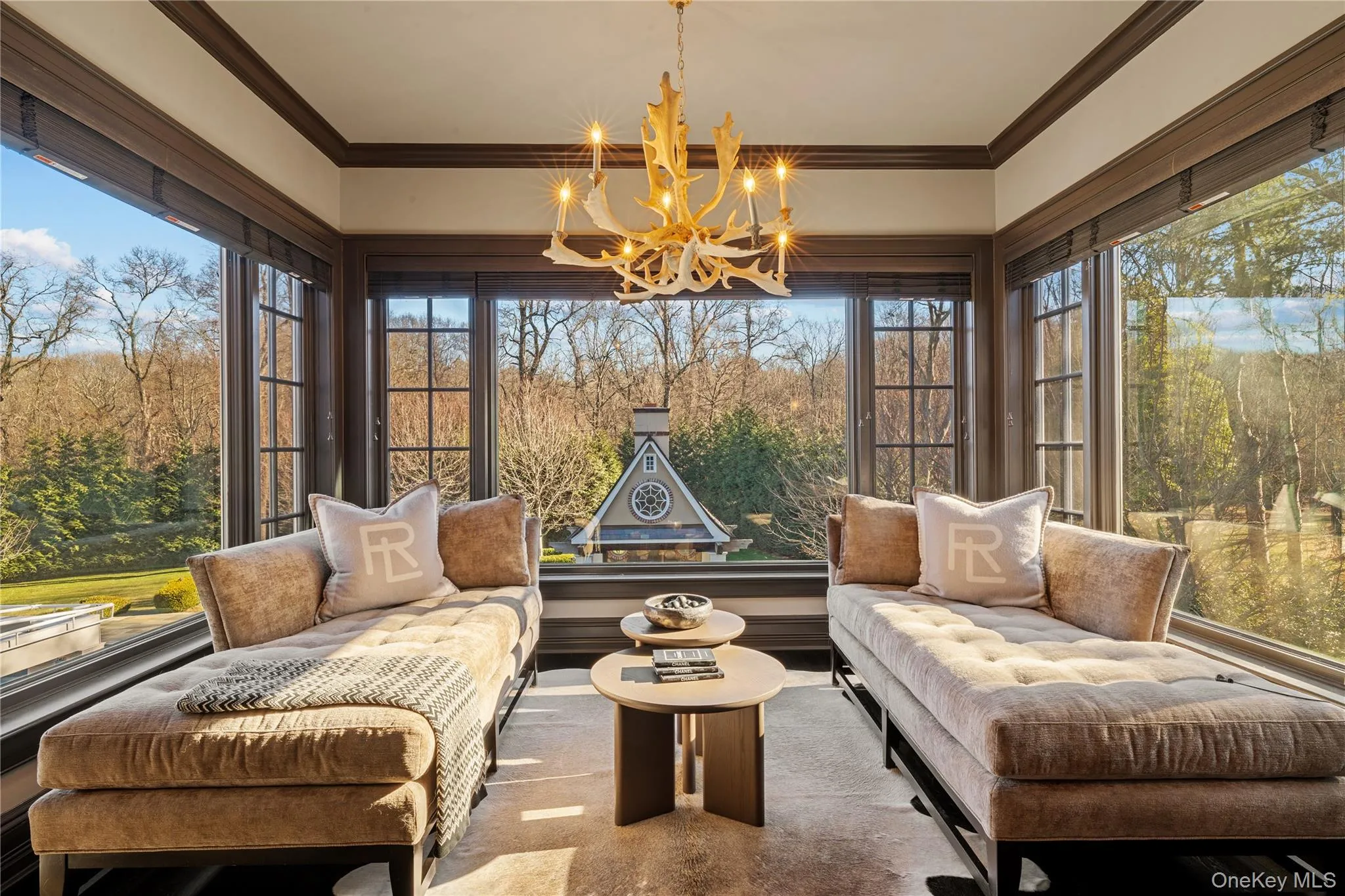 Sunroom / solarium with crown molding, view of wooded area, healthy amount of natural light, and a chandelier Sunroom / solarium with crown molding, view of wooded area, healthy amount of natural light, and a chandelier