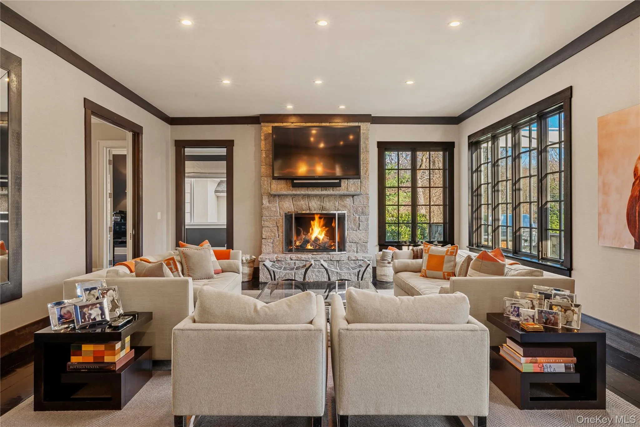 Living room featuring a stone fireplace, recessed lighting, and crown molding Living room featuring a stone fireplace, recessed lighting, and crown molding