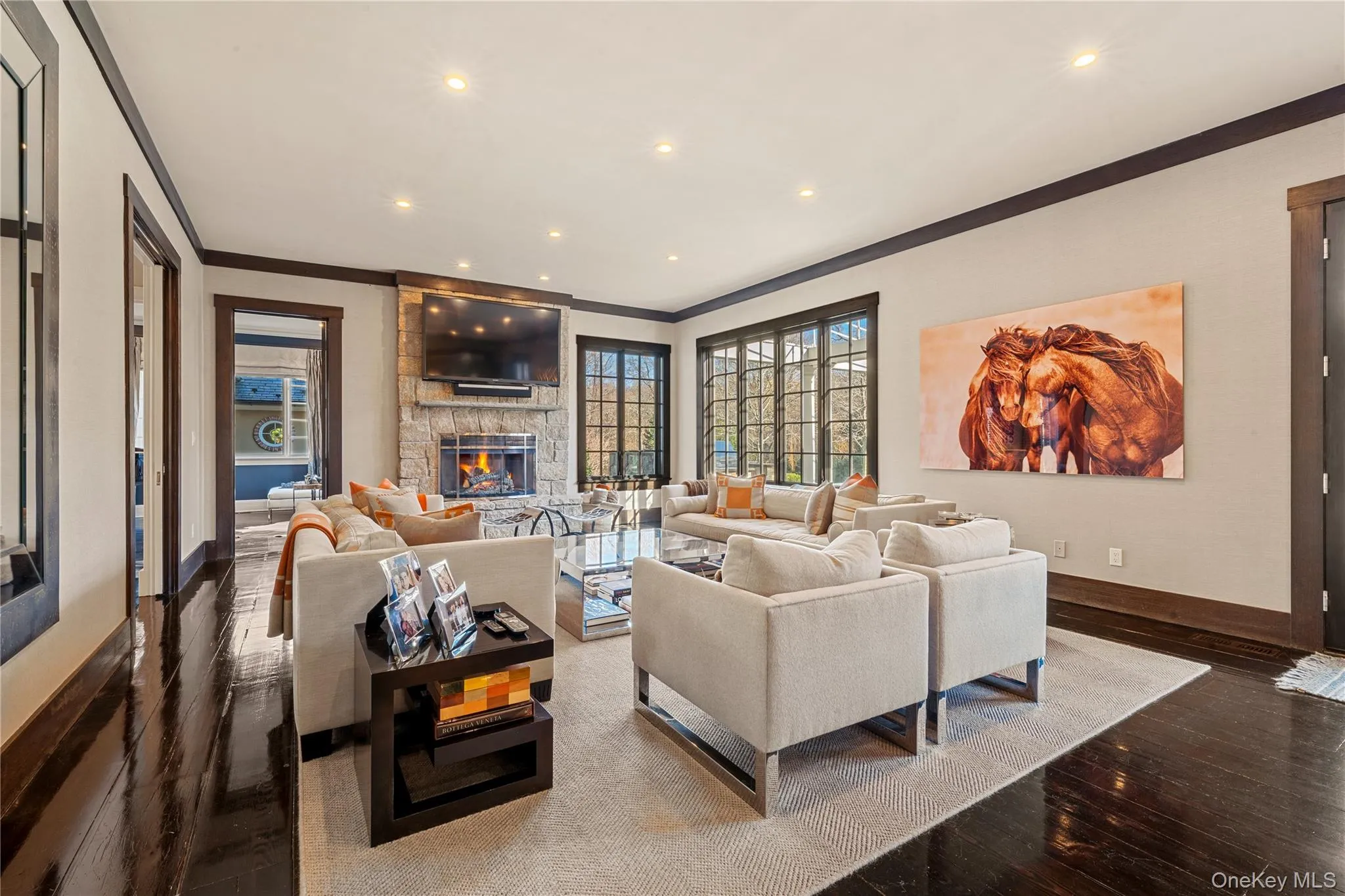 Living room featuring recessed lighting, a fireplace, hardwood / wood-style floors, and crown molding Living room featuring recessed lighting, a fireplace, hardwood / wood-style floors, and crown molding