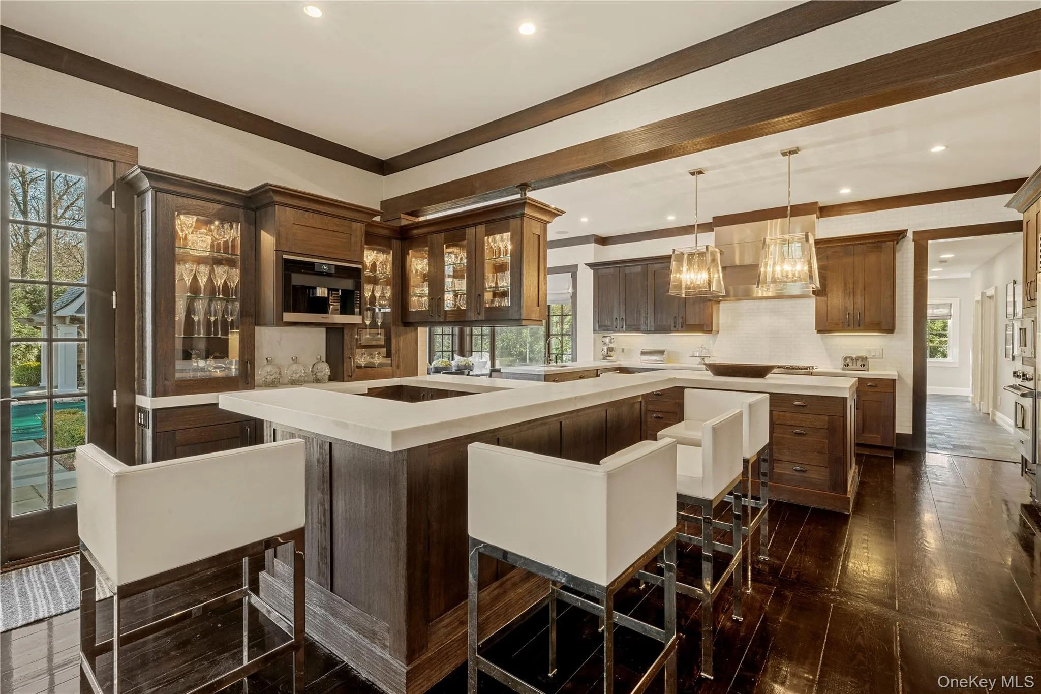Bar with glass insert cabinets, light countertops, plenty of natural light, hanging light fixtures, and recessed lighting Bar with glass insert cabinets, light countertops, plenty of natural light, hanging light fixtures, and recessed lighting