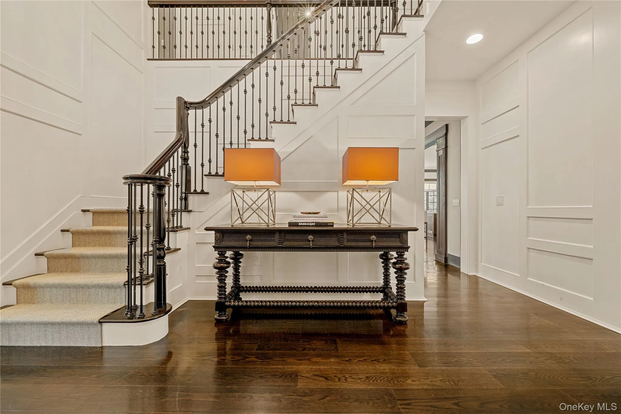 Foyer entrance with a decorative wall, stairs, and dark wood-style floors Foyer entrance with a decorative wall, stairs, and dark wood-style floors