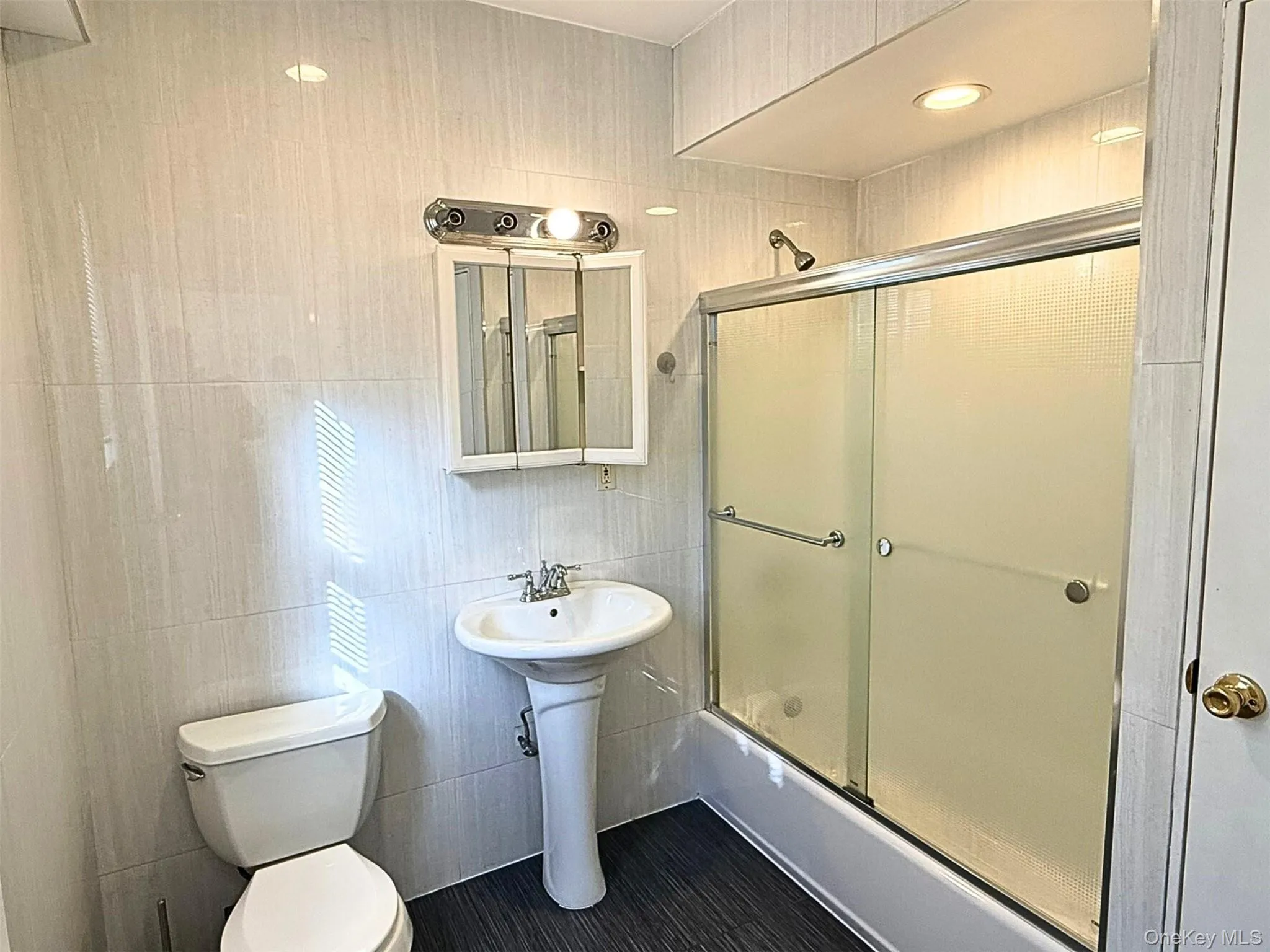 Full bath with combined bath / shower with glass door and tile walls Full bath with combined bath / shower with glass door and tile walls