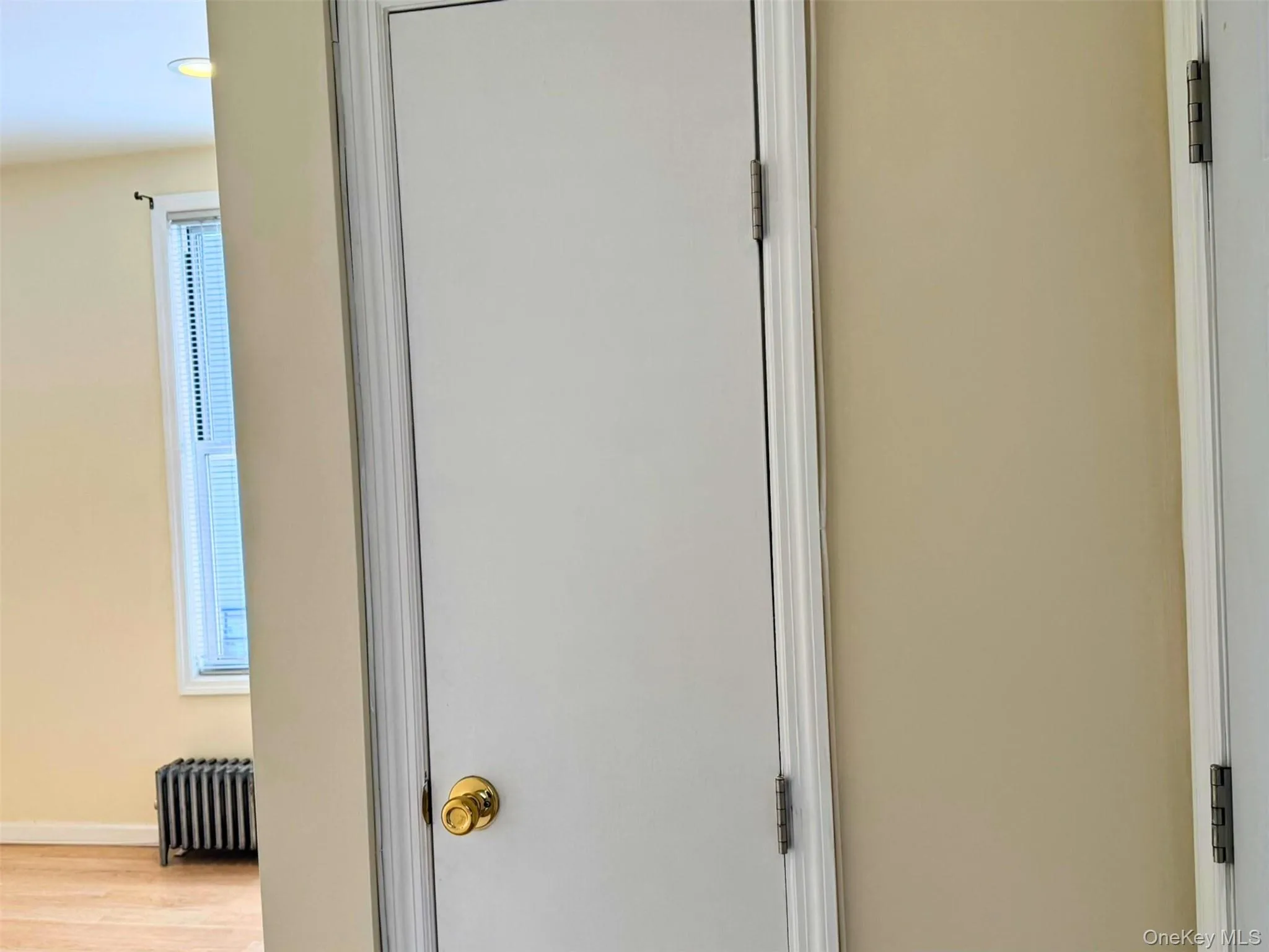 Detailed view of radiator heating unit and wood finished floors Detailed view of radiator heating unit and wood finished floors