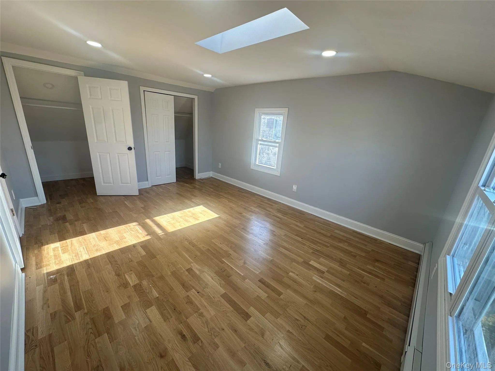 Unfurnished bedroom featuring light wood-style flooring, a closet, a skylight, vaulted ceiling, and recessed lighting Unfurnished bedroom featuring light wood-style flooring, a closet, a skylight, vaulted ceiling, and recessed lighting