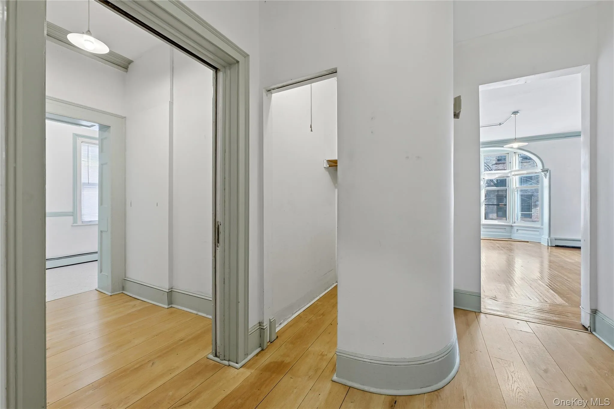 Hall with light wood-style flooring and a baseboard radiator Hall with light wood-style flooring and a baseboard radiator