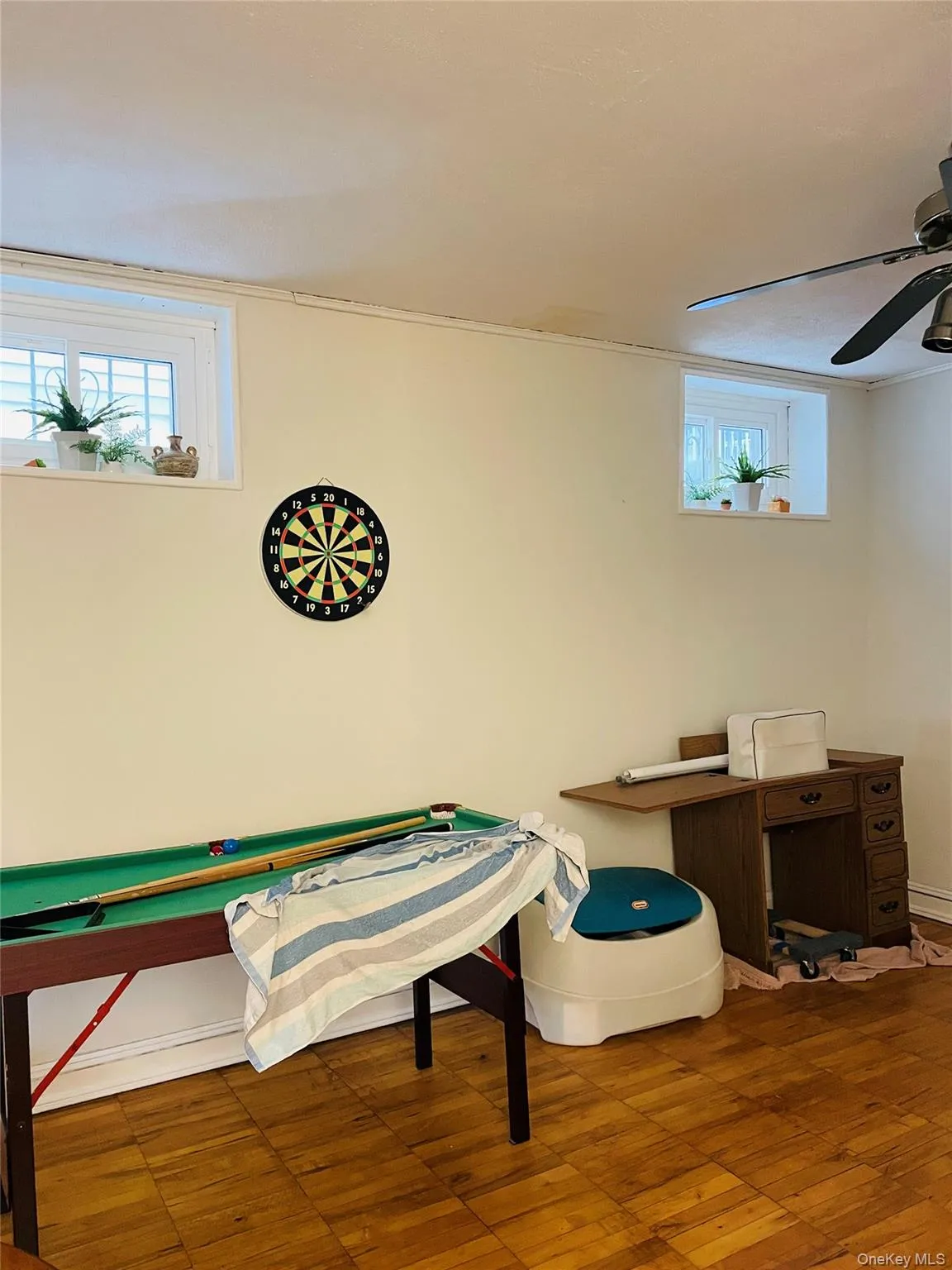 Playroom featuring healthy amount of natural light, crown molding, hardwood / wood-style flooring, and ceiling fan Playroom featuring healthy amount of natural light, crown molding, hardwood / wood-style flooring, and ceiling fan