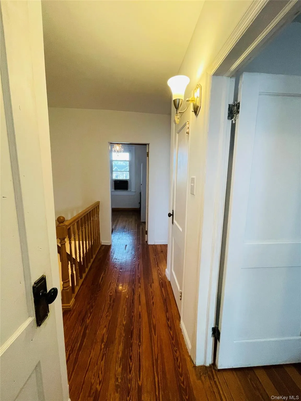 Hall featuring dark wood-type flooring and an upstairs landing Hall featuring dark wood-type flooring and an upstairs landing