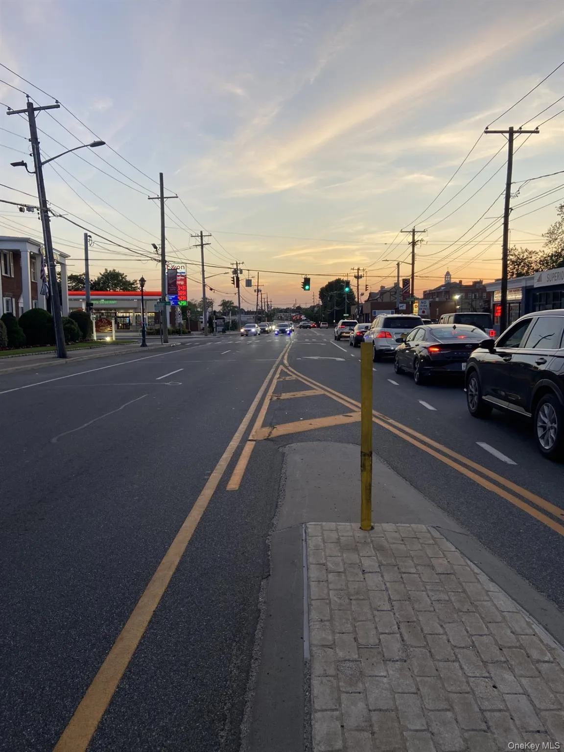 View of asphalt street with street lighting, sidewalks, and curbs View of asphalt street with street lighting, sidewalks, and curbs