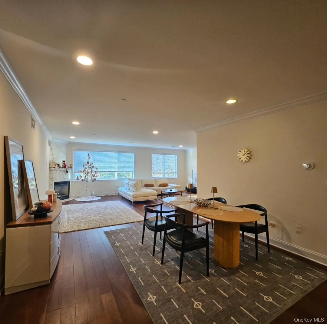Dining space featuring crown molding, dark wood-type flooring, a tiled fireplace, and recessed lighting Dining space featuring crown molding, dark wood-type flooring, a tiled fireplace, and recessed lighting