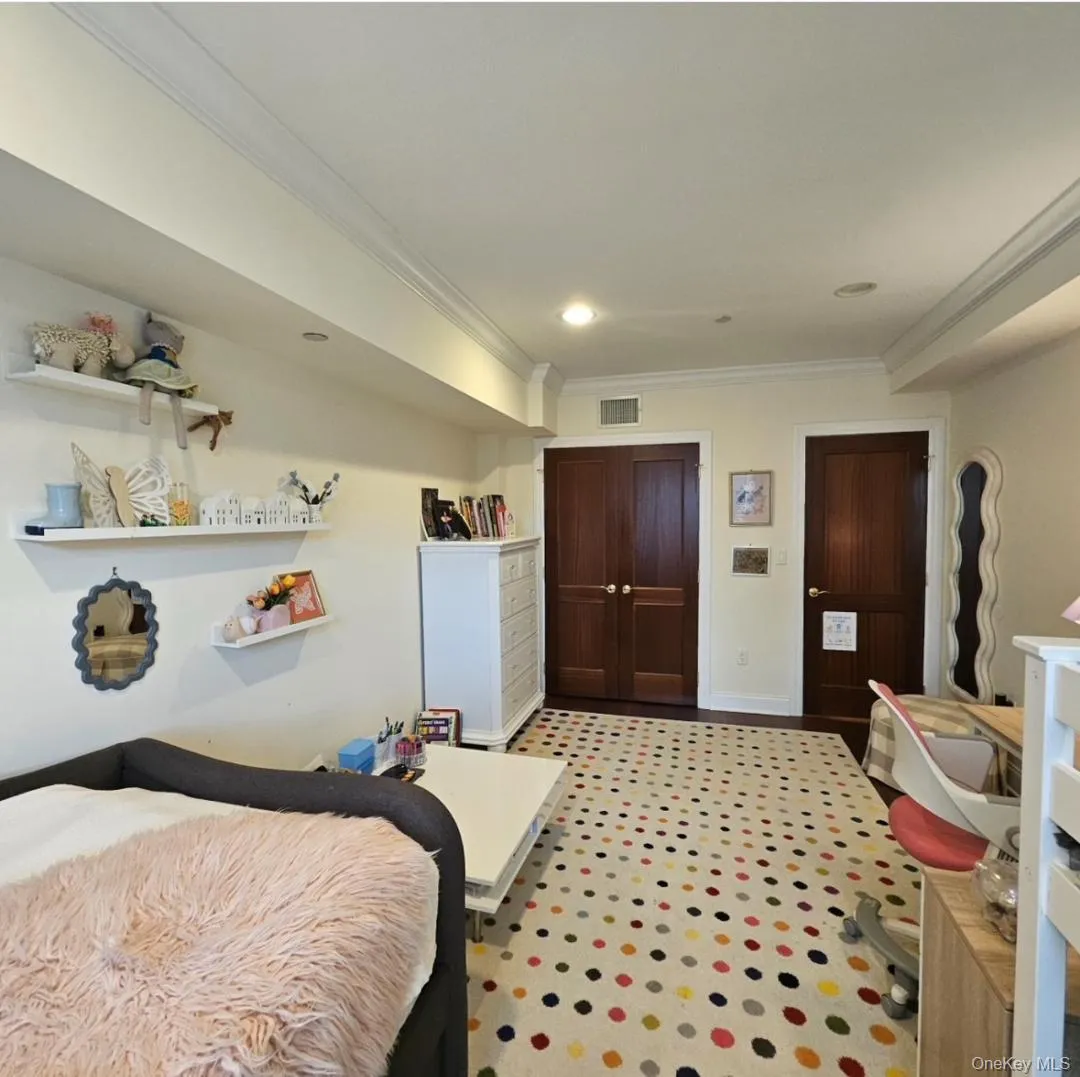 Bedroom featuring crown molding and a closet Bedroom featuring crown molding and a closet