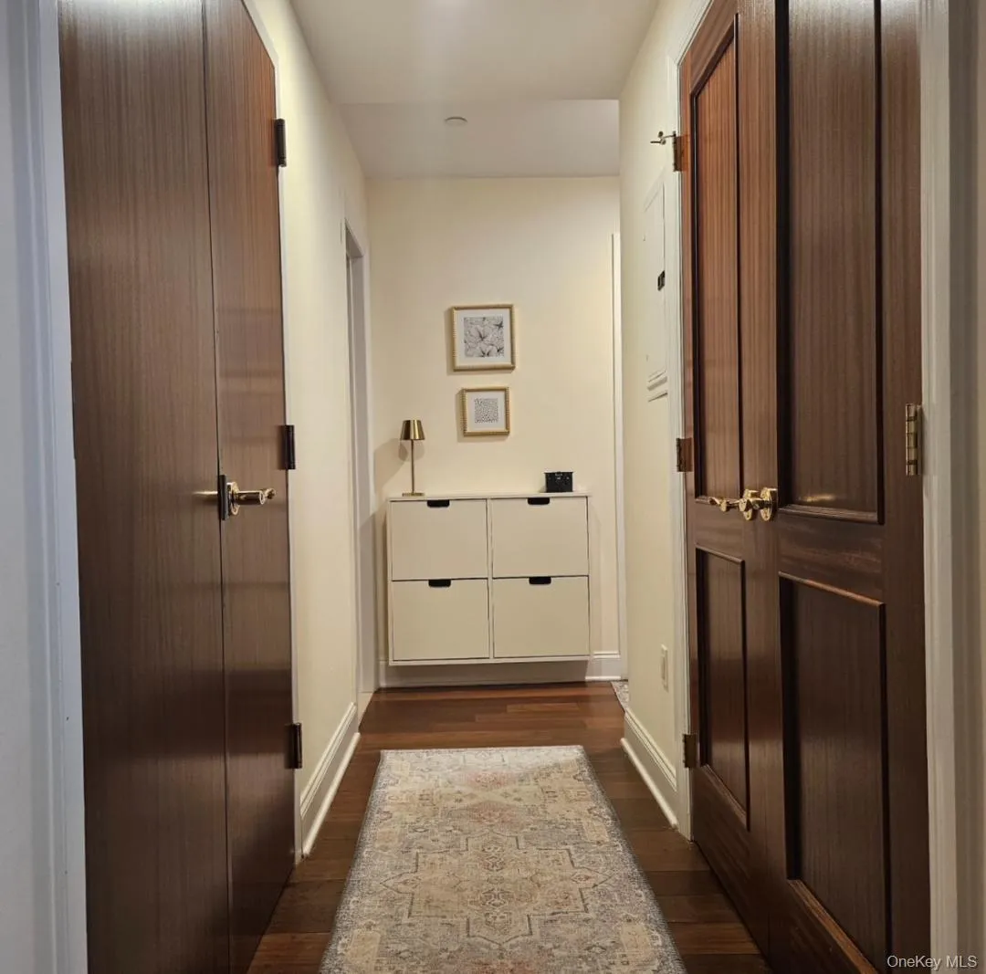 Hallway with dark wood finished floors and baseboards Hallway with dark wood finished floors and baseboards