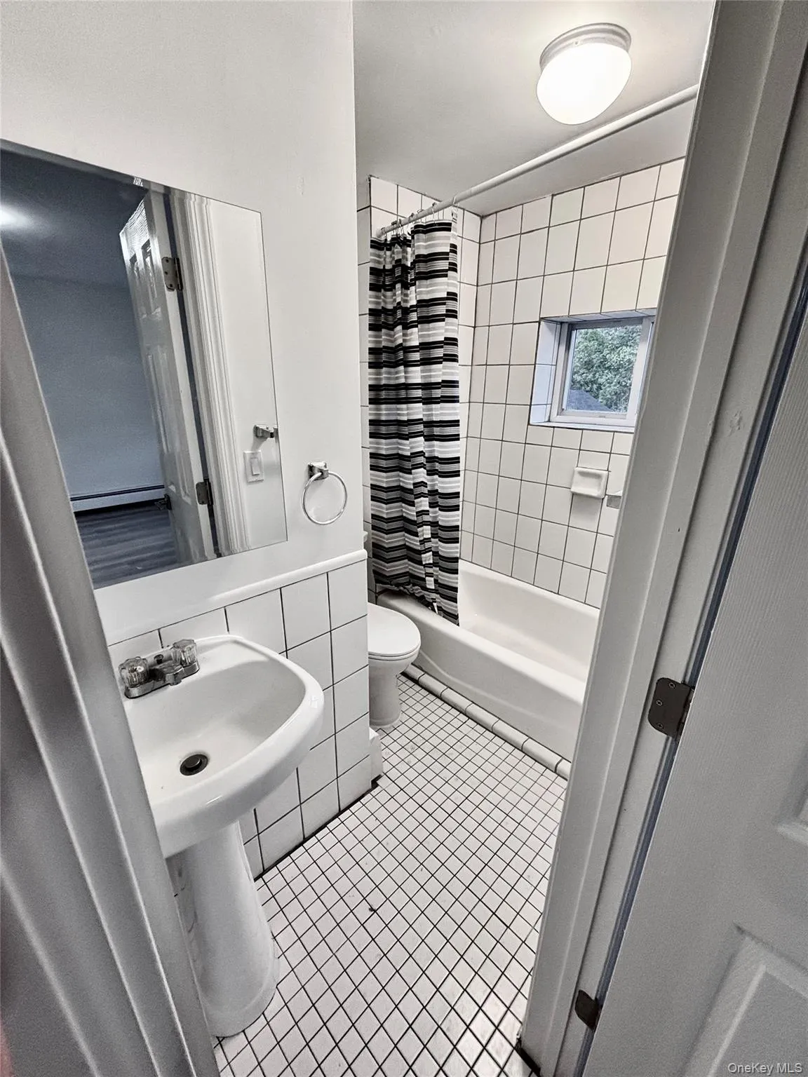 Bathroom with tile patterned floors, toilet, and shower / bath combination with curtain Bathroom with tile patterned floors, toilet, and shower / bath combination with curtain