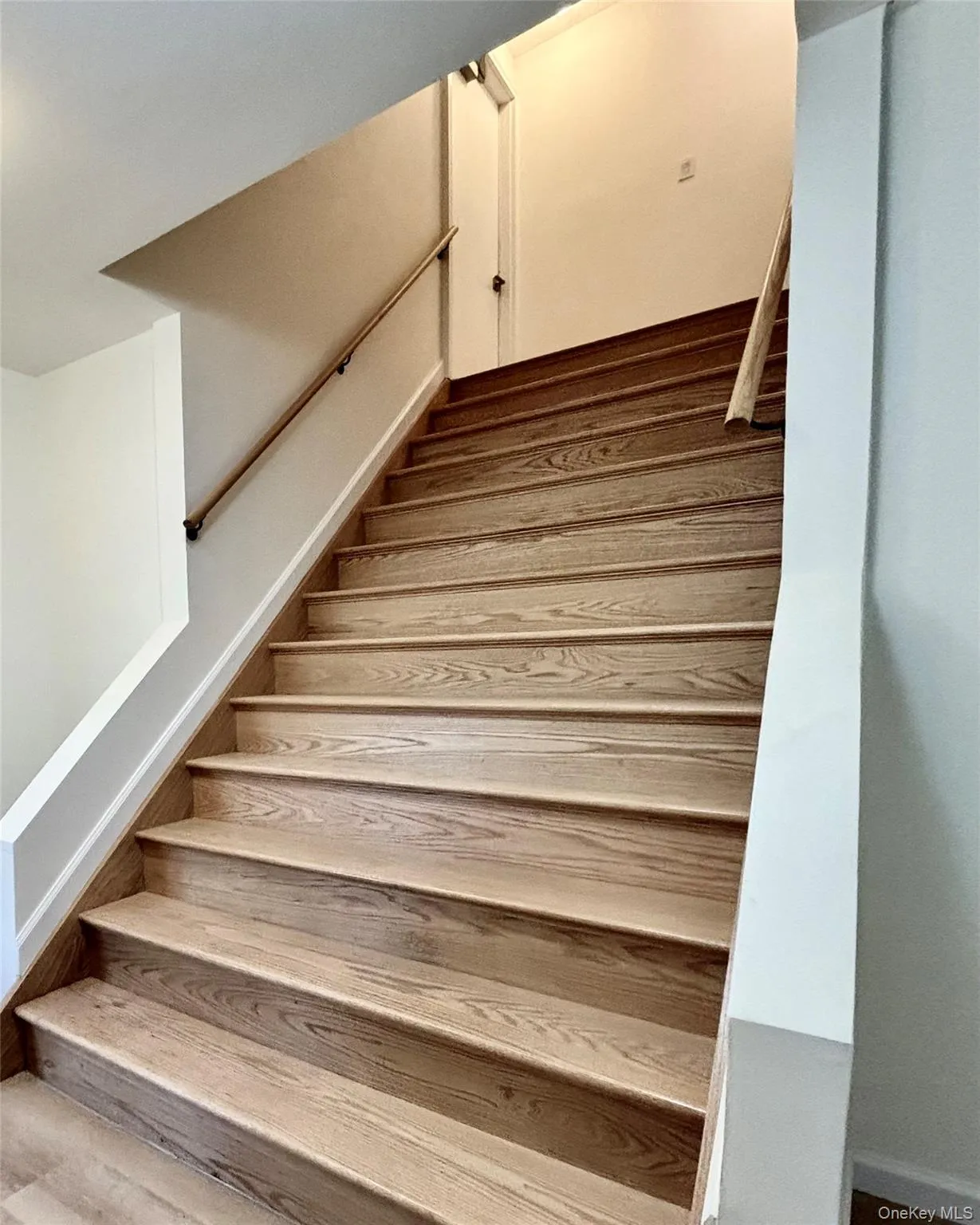Stairway featuring wood finished floors Stairway featuring wood finished floors