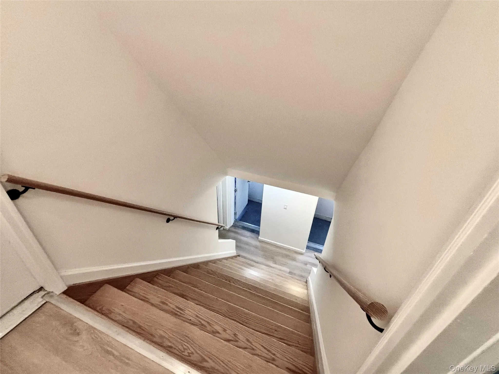Staircase featuring baseboards and vaulted ceiling Staircase featuring baseboards and vaulted ceiling