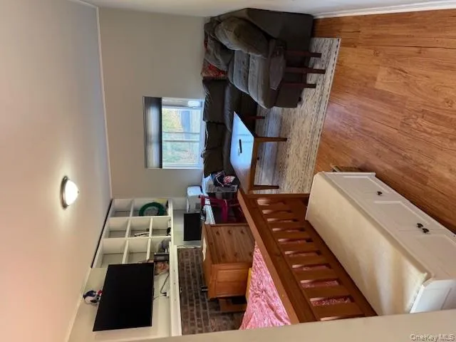 Living room featuring light wood-type flooring and crown molding Living room featuring light wood-type flooring and crown molding