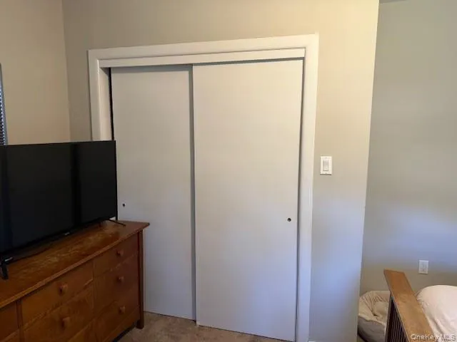 Bedroom featuring light colored carpet and a closet Bedroom featuring light colored carpet and a closet
