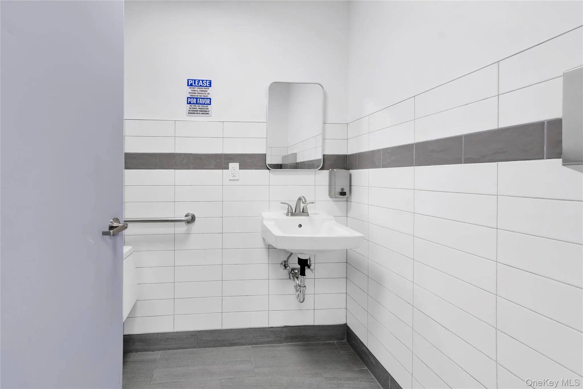 Bathroom with tile walls and a sink Bathroom with tile walls and a sink