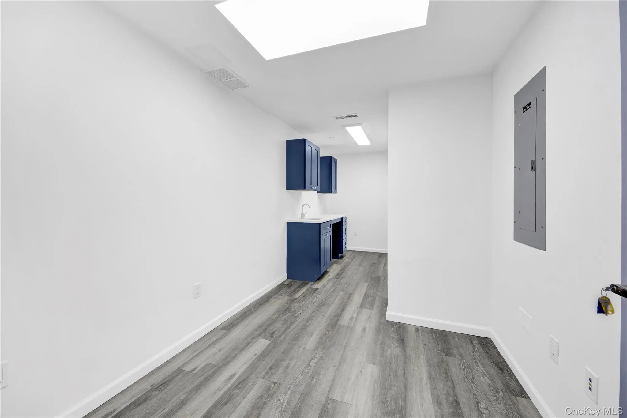 Spare room featuring electric panel and light wood-type flooring Spare room featuring electric panel and light wood-type flooring