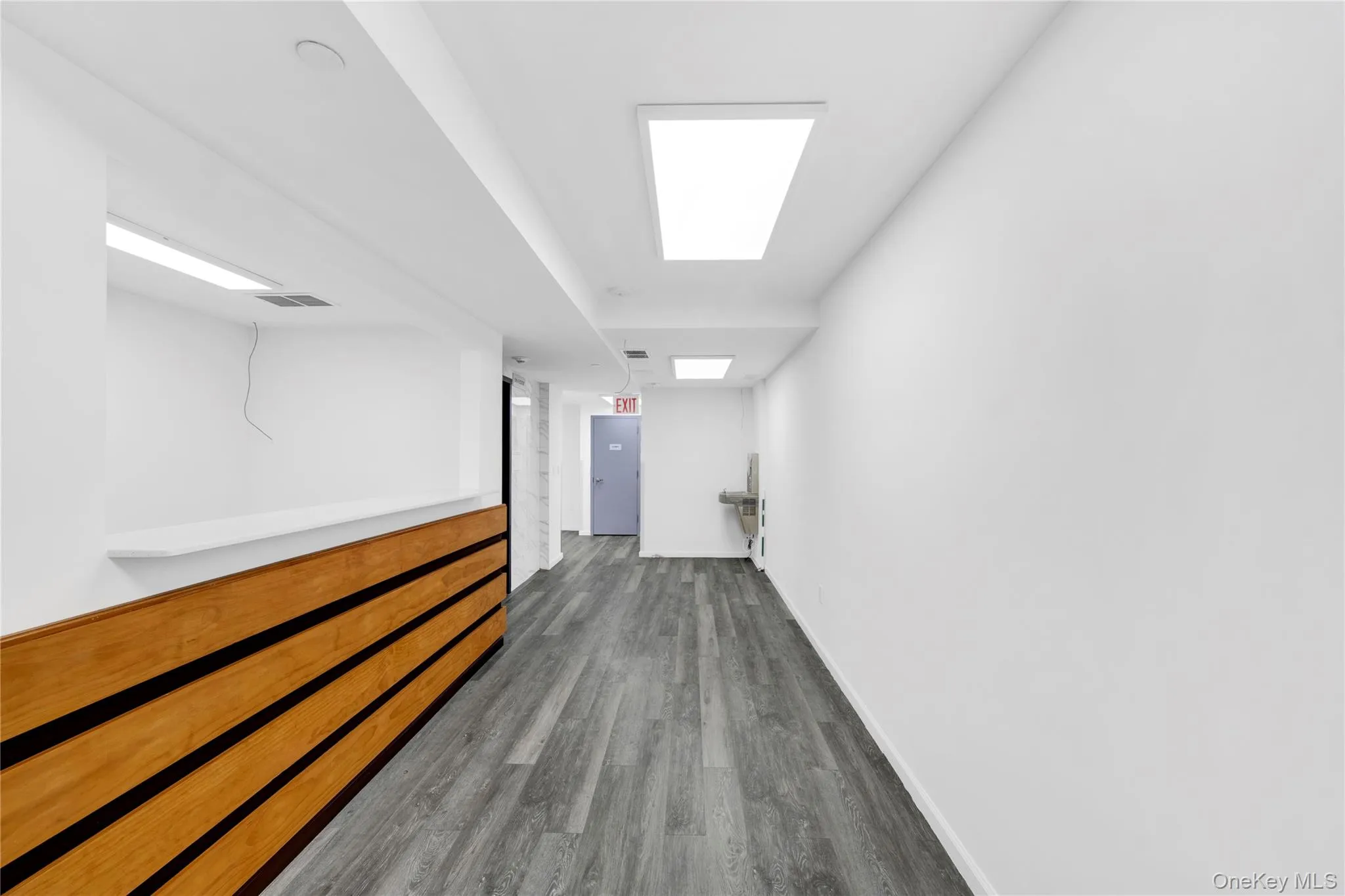 Hallway with baseboards and wood finished floors Hallway with baseboards and wood finished floors