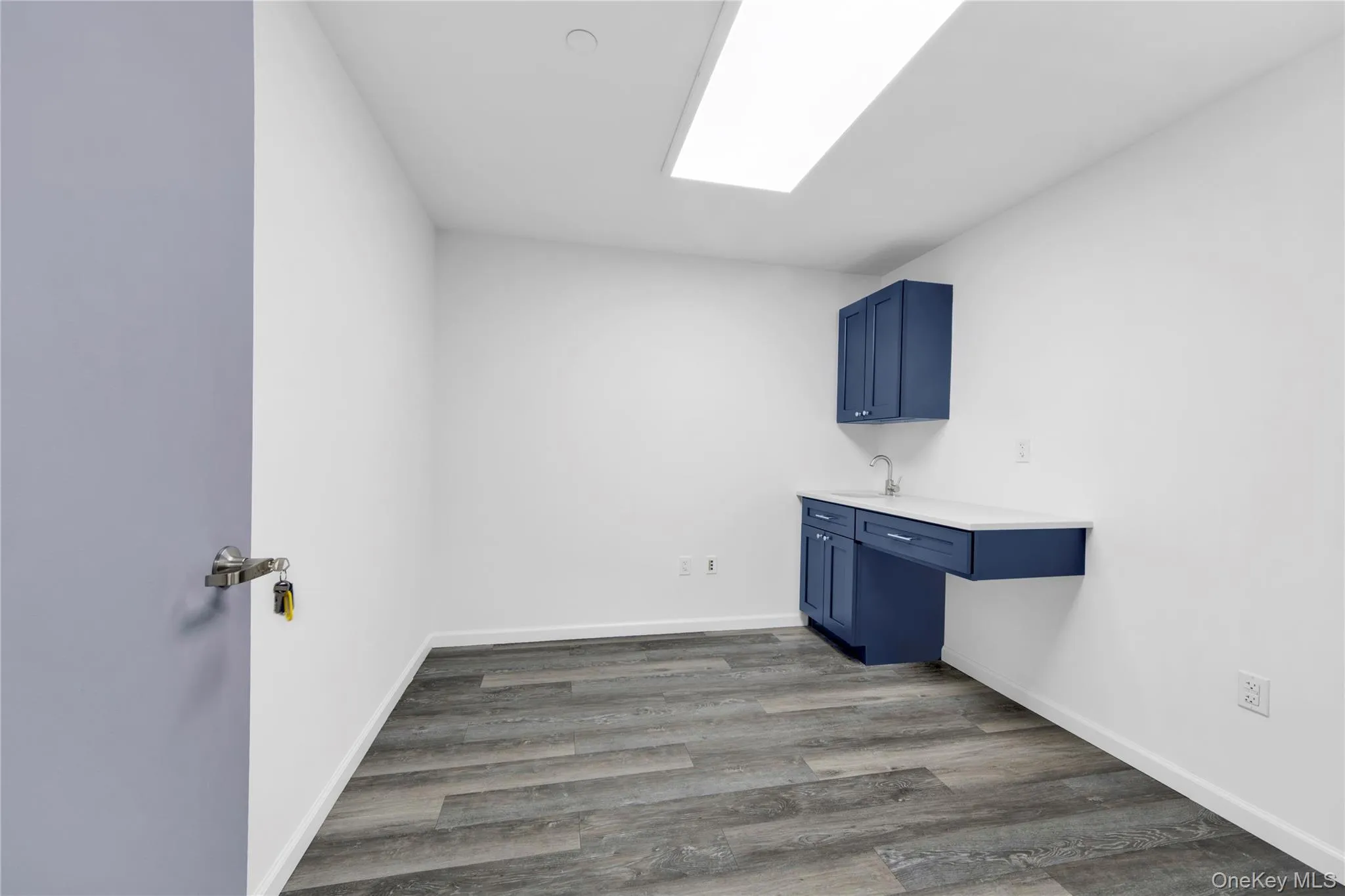 Laundry room featuring dark wood-style floors and baseboards Laundry room featuring dark wood-style floors and baseboards