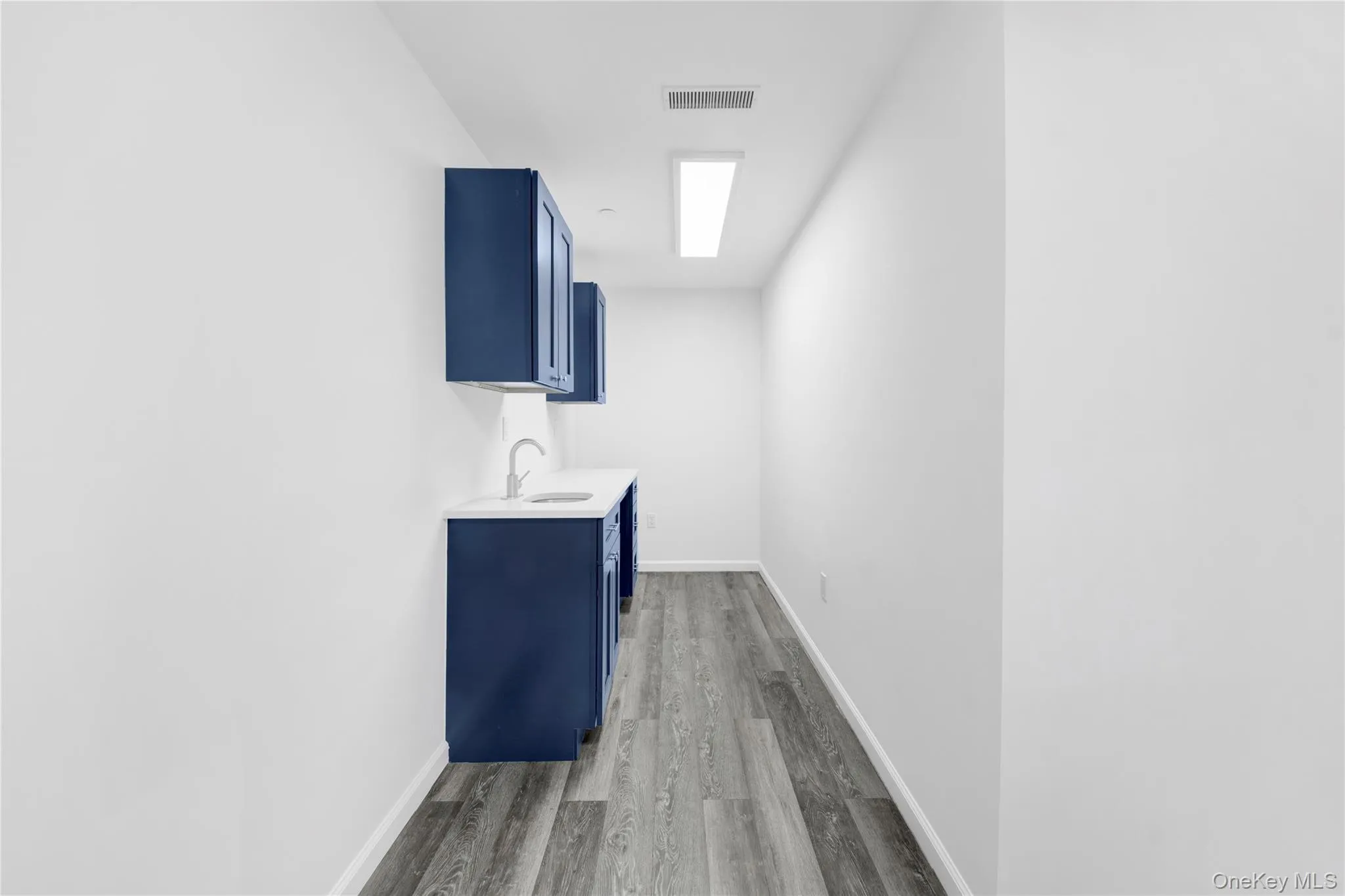 Laundry area featuring dark wood-style flooring and cabinet space Laundry area featuring dark wood-style flooring and cabinet space
