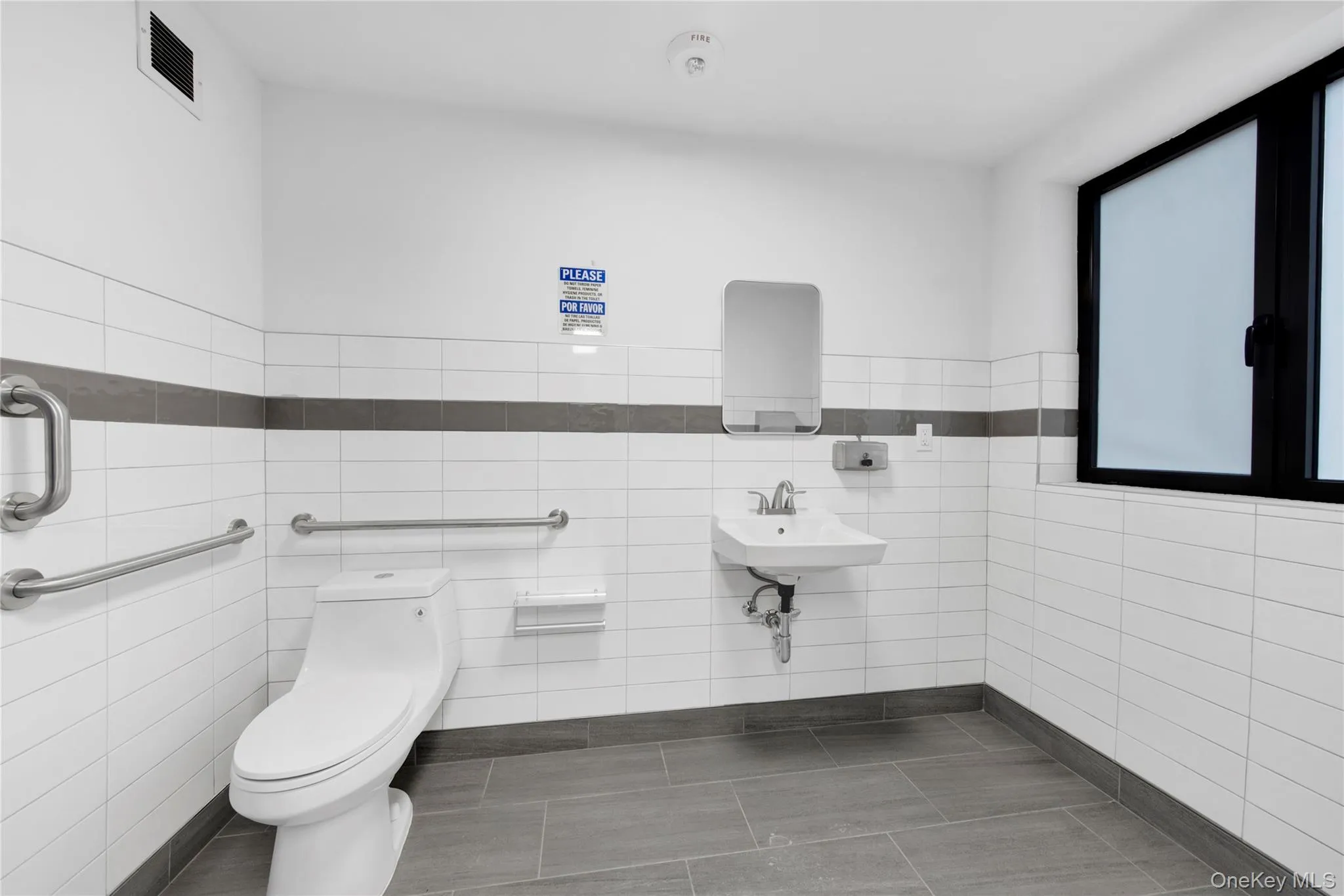 Half bathroom with tile patterned floors and tile walls Half bathroom with tile patterned floors and tile walls