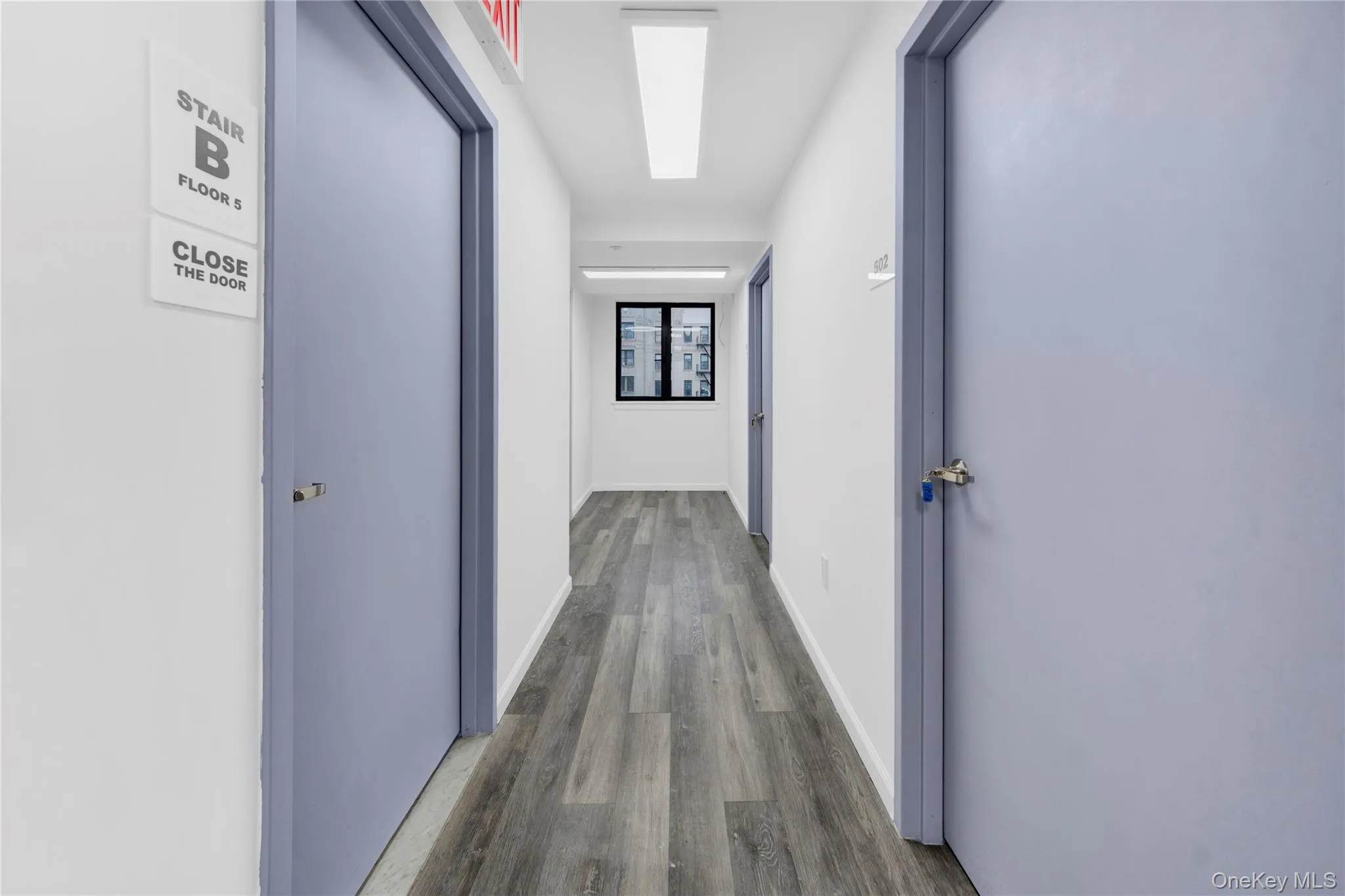 Hall with dark wood finished floors and a skylight Hall with dark wood finished floors and a skylight
