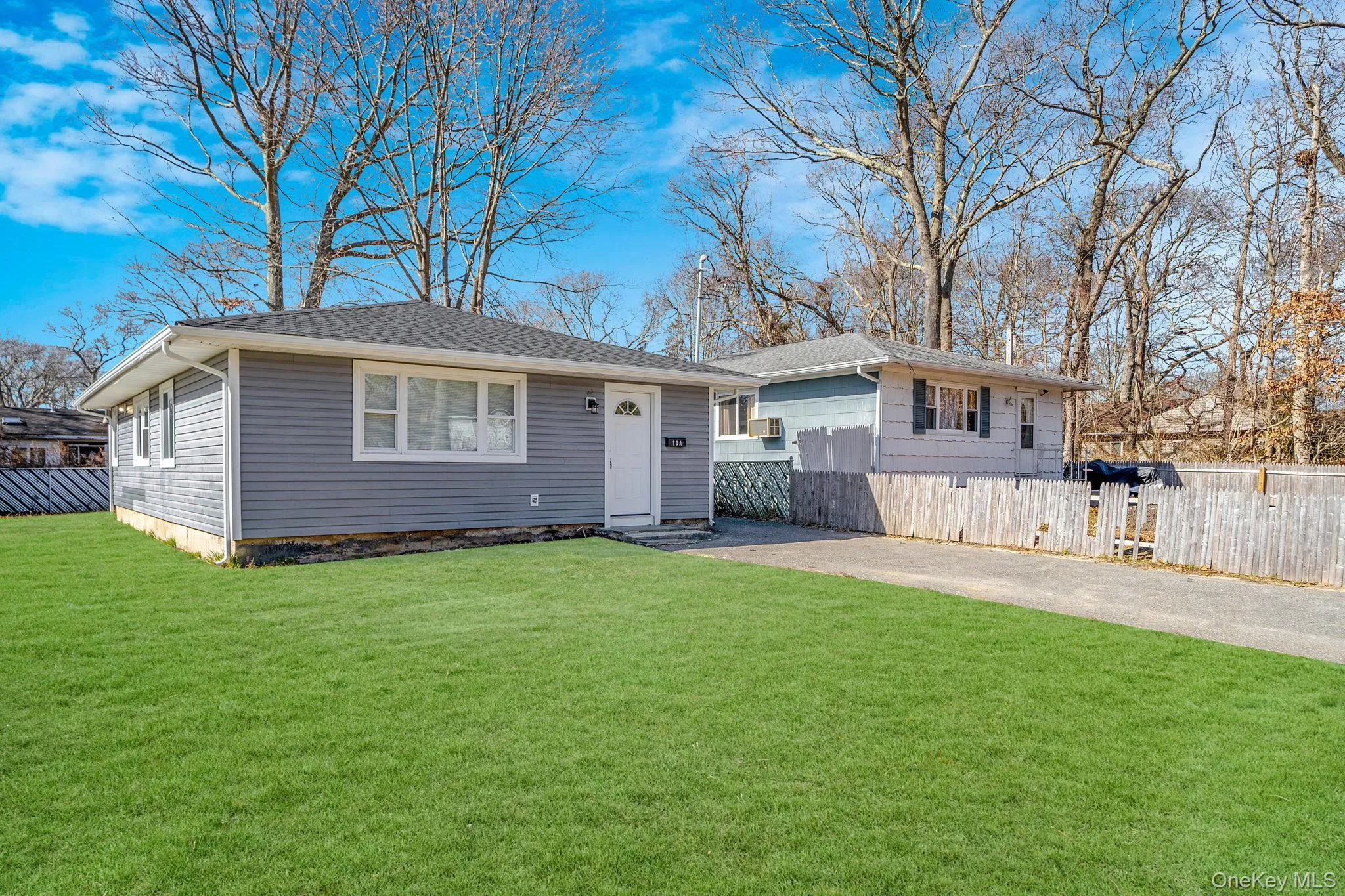 View of front of home with a shingled roof and driveway View of front of home with a shingled roof and driveway