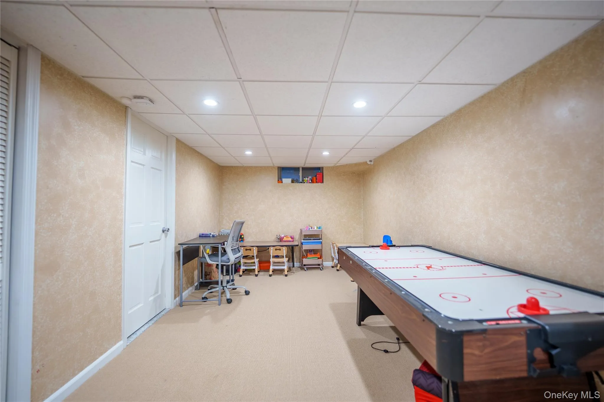 Opposite side of Rec room featuring recessed lighting, a desk, light carpet, and a drop ceiling. White door is full bath entrance Opposite side of Rec room featuring recessed lighting, a desk, light carpet, and a drop ceiling. White door is full bath entrance