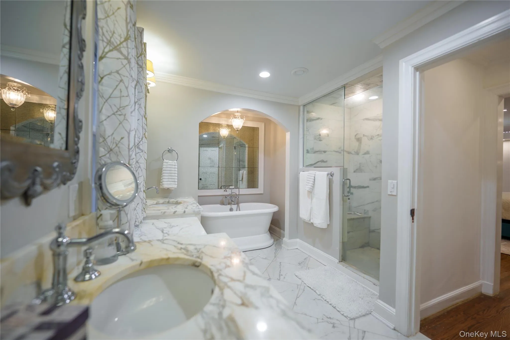 Ensuite primary bathroom featuring crown molding, rain shower, double vanity, toilet room and a soaking tub Ensuite primary bathroom featuring crown molding, rain shower, double vanity, toilet room and a soaking tub