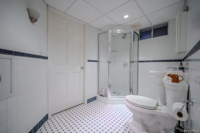 Full bath with tile walls, a stall shower for the lower level Full bath with tile walls, a stall shower for the lower level