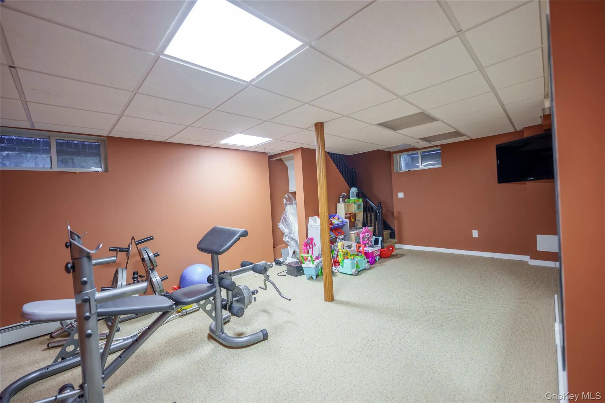 Workout room featuring a paneled ceiling, and back staircase Workout room featuring a paneled ceiling, and back staircase