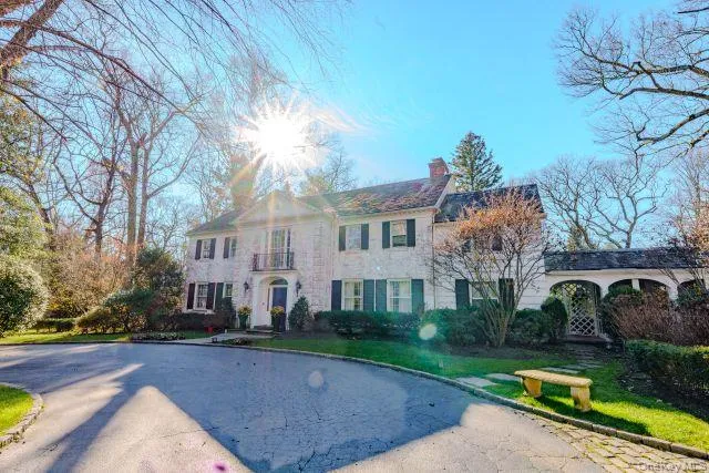 View of front facade with a chimney and driveway View of front facade with a chimney and driveway