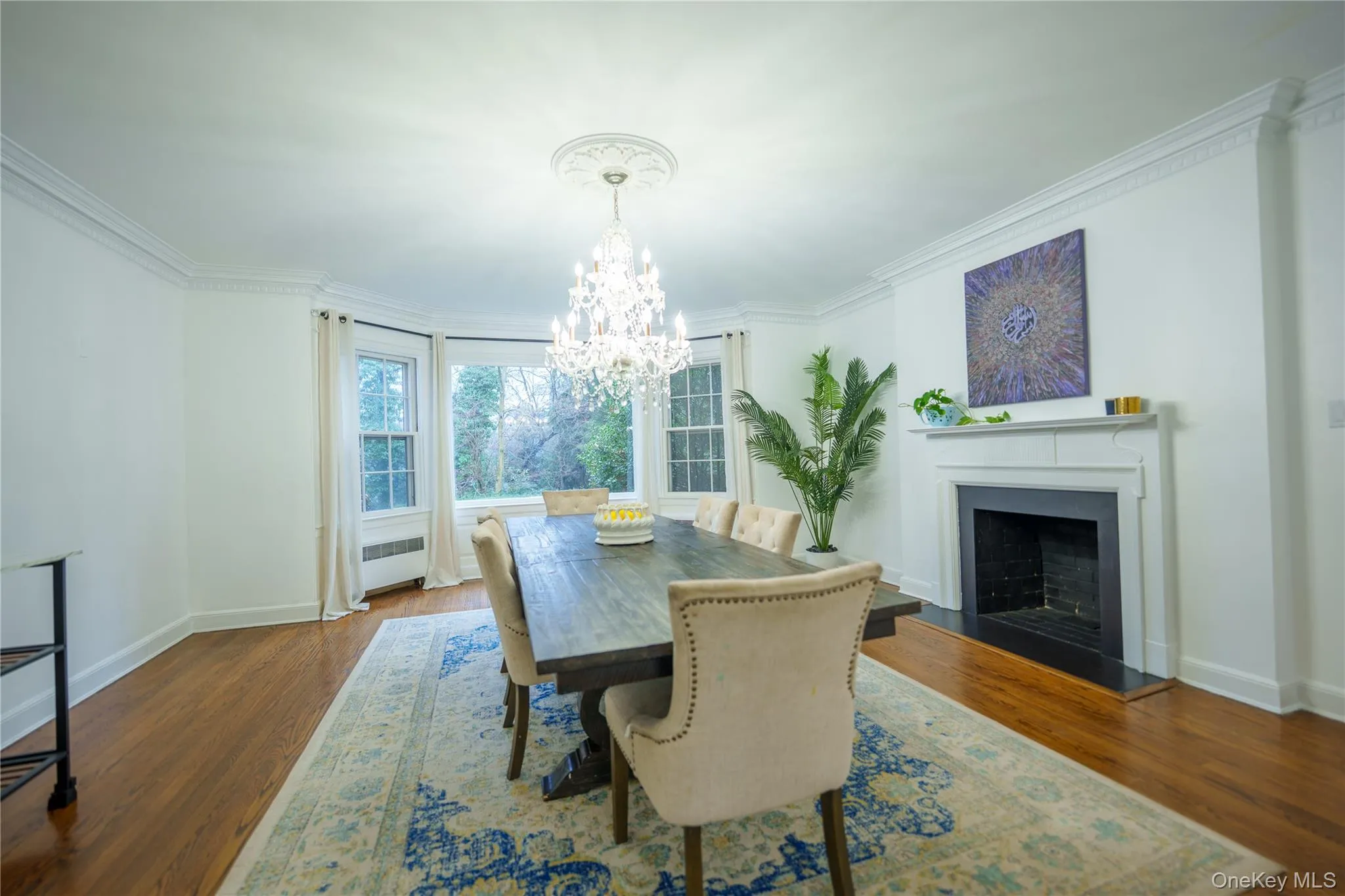 Formal Dining room featuring 2 fireplace, original moldings, chandelier, hard wood floors, and views of property Formal Dining room featuring 2 fireplace, original moldings, chandelier, hard wood floors, and views of property