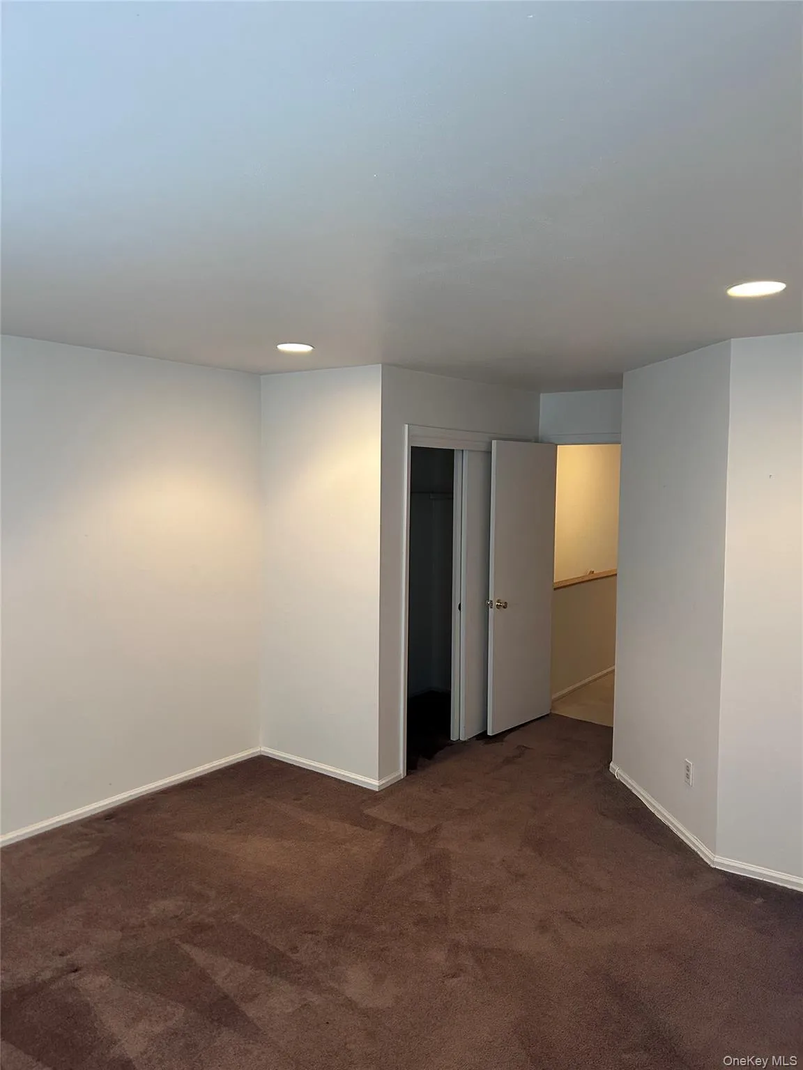 Empty room featuring recessed lighting and dark colored carpet Empty room featuring recessed lighting and dark colored carpet