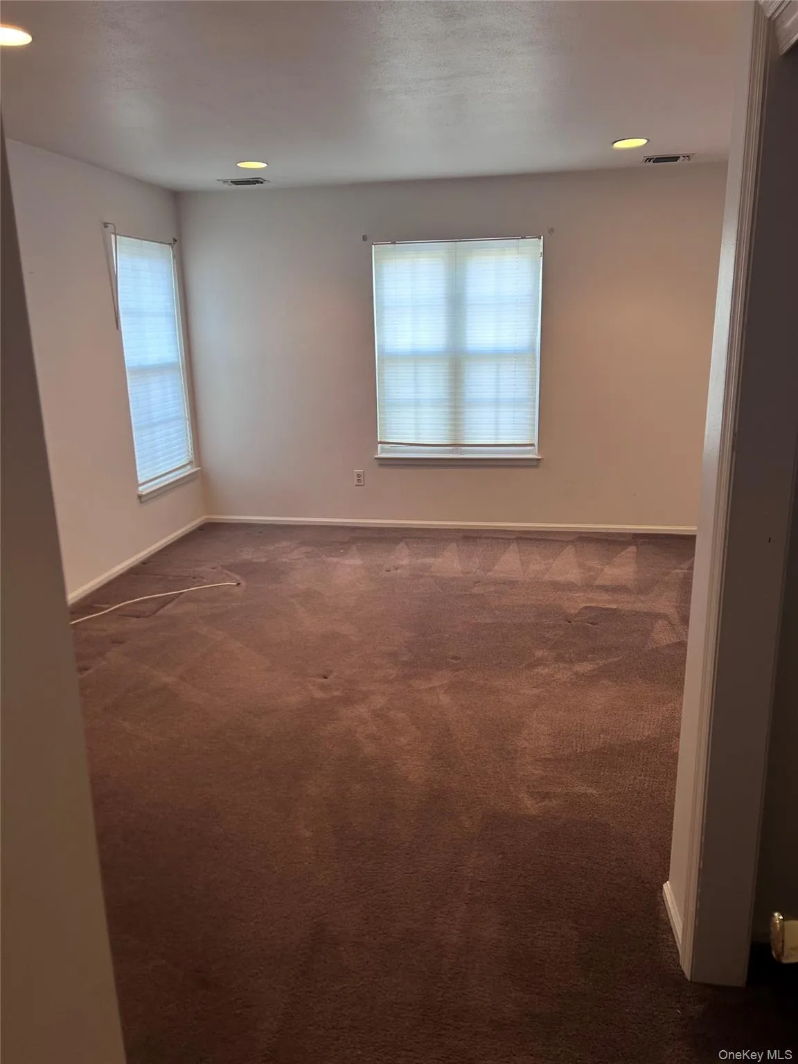 Spare room featuring recessed lighting and dark carpet Spare room featuring recessed lighting and dark carpet