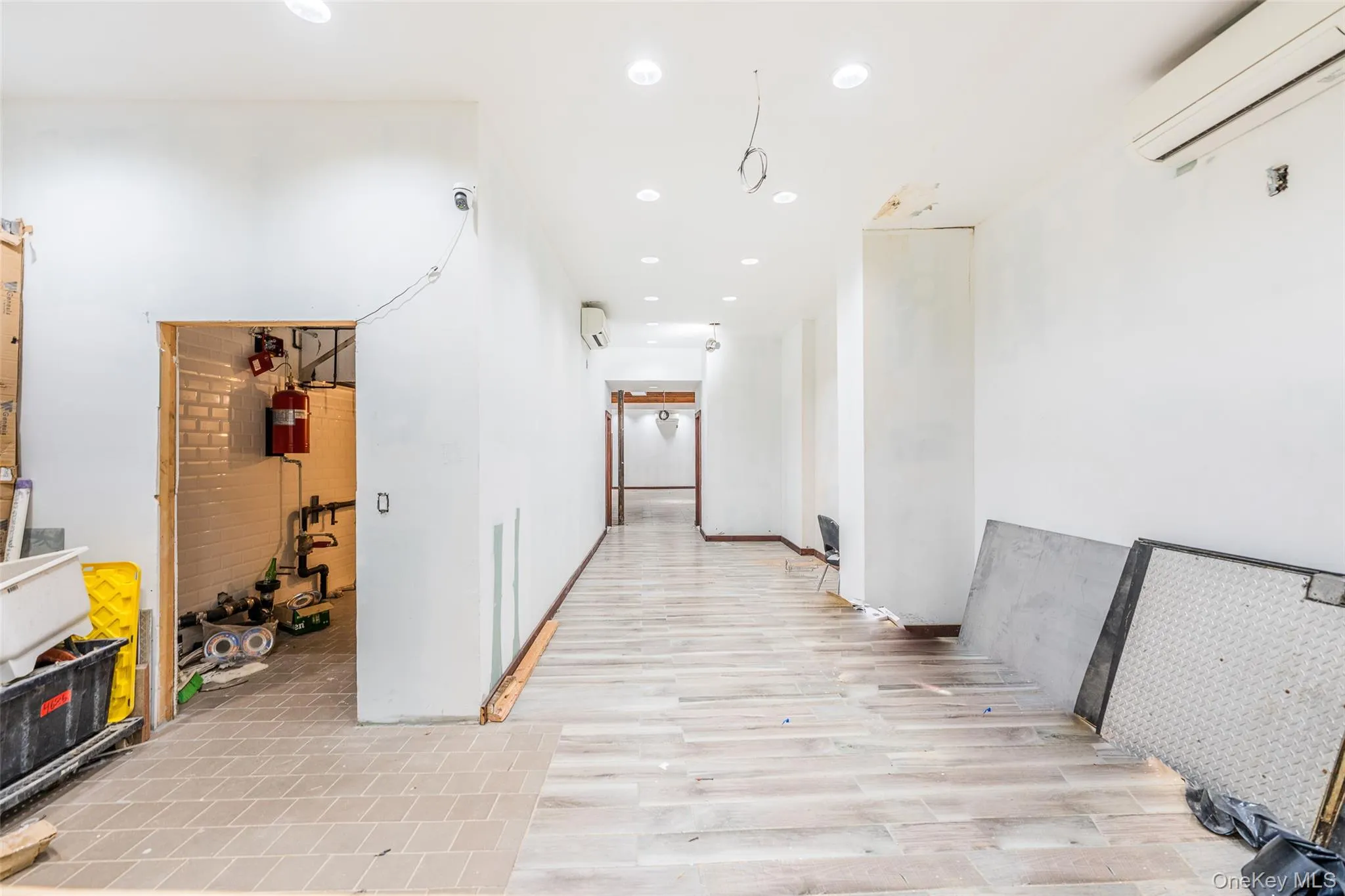 Corridor featuring a wall mounted air conditioner, recessed lighting, and light wood-type flooring Corridor featuring a wall mounted air conditioner, recessed lighting, and light wood-type flooring
