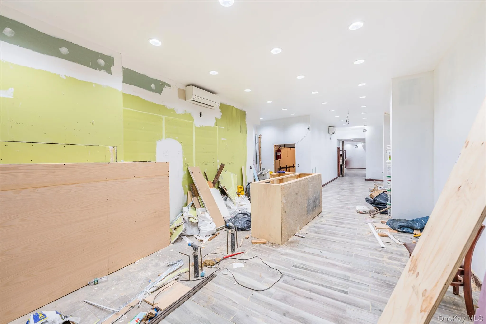 Hallway featuring recessed lighting, wood finished floors, and a wall unit AC Hallway featuring recessed lighting, wood finished floors, and a wall unit AC