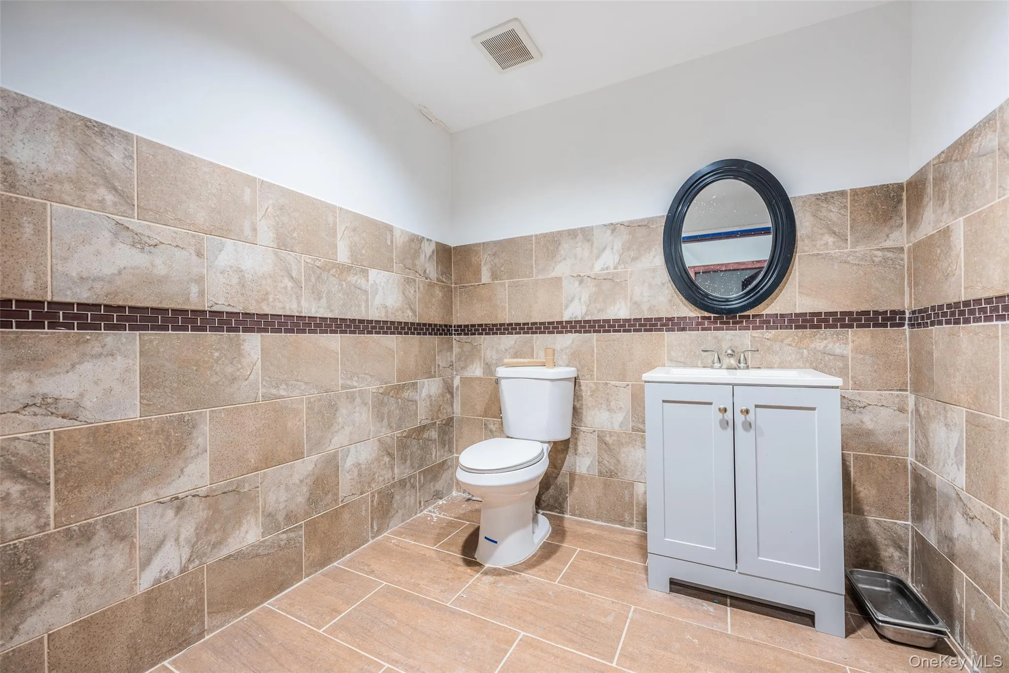 Half bathroom with vanity and tile walls Half bathroom with vanity and tile walls