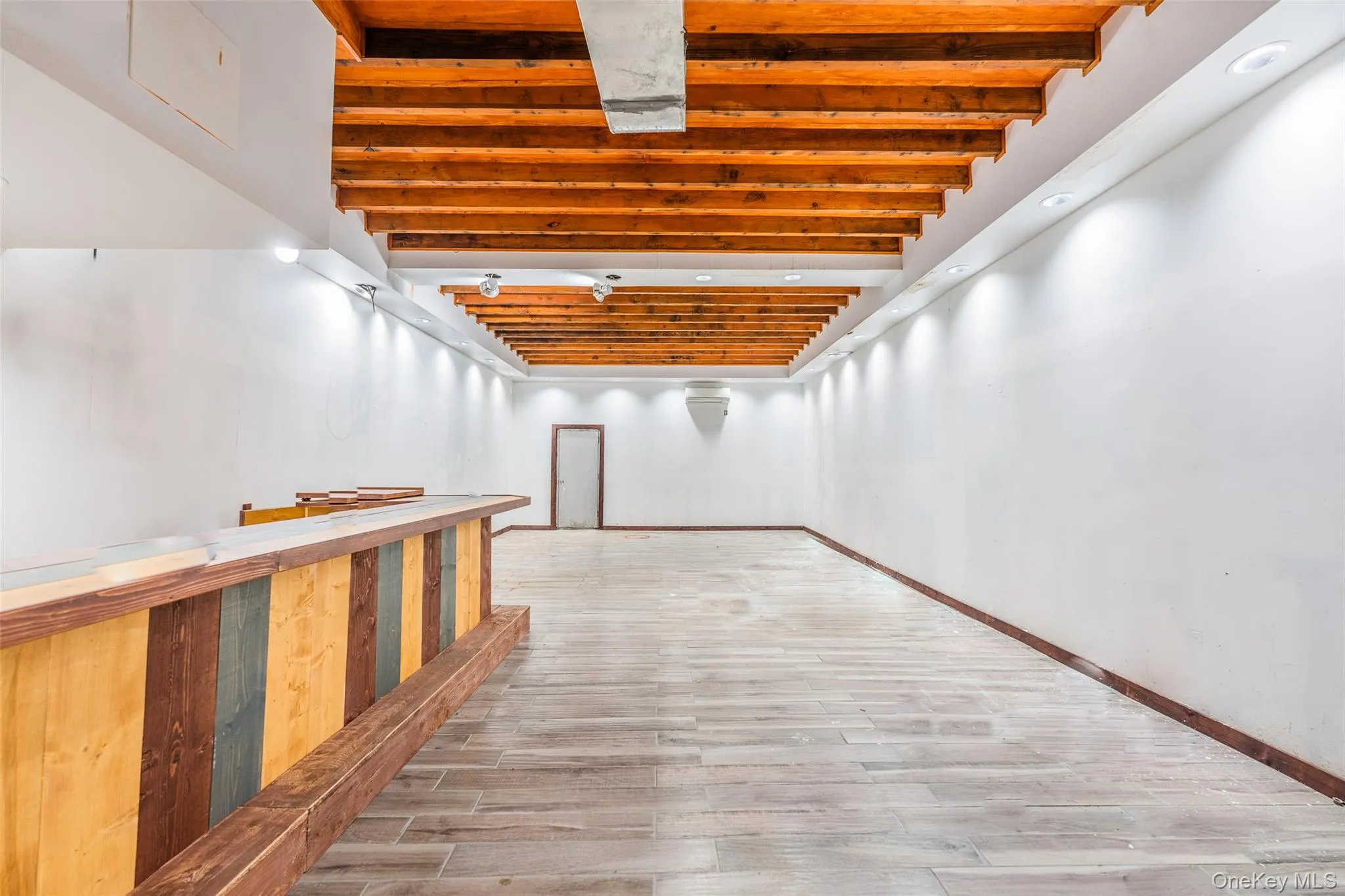 Corridor with wood finish floors and beamed ceiling Corridor with wood finish floors and beamed ceiling
