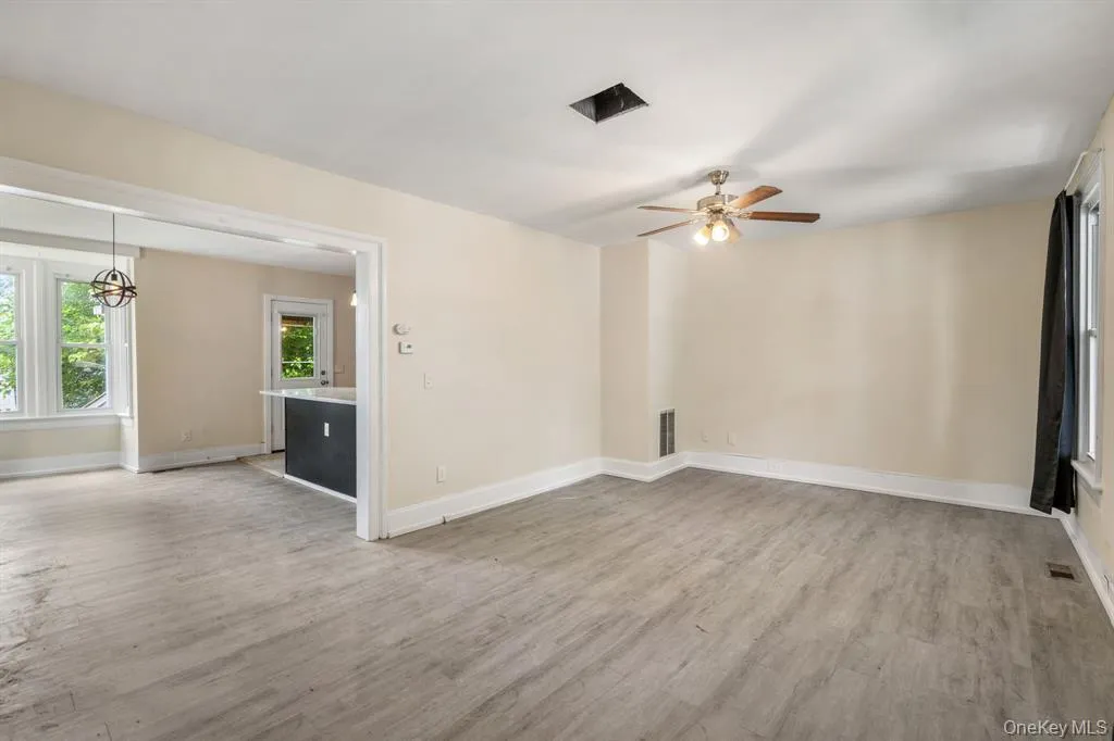 Empty room featuring light wood-style flooring and a ceiling fan Empty room featuring light wood-style flooring and a ceiling fan