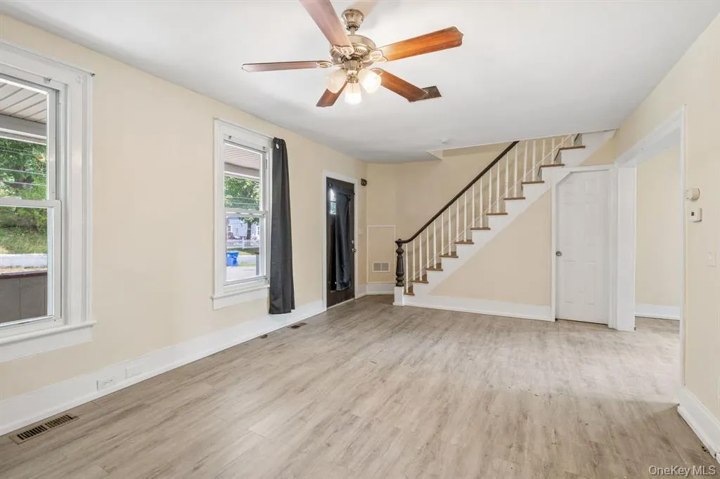 Foyer with light wood-type flooring, stairs, and ceiling fan Foyer with light wood-type flooring, stairs, and ceiling fan