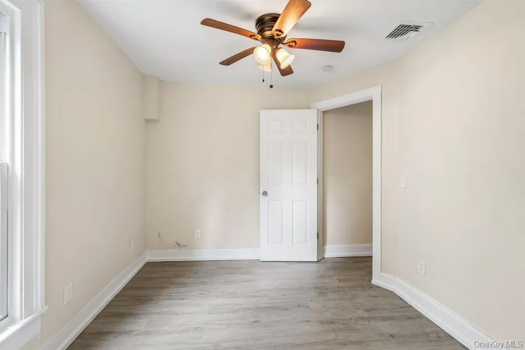 Spare room featuring light wood-style floors and a ceiling fan Spare room featuring light wood-style floors and a ceiling fan