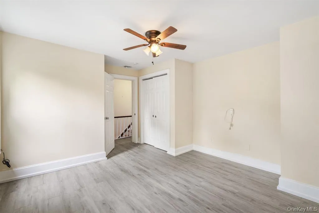 Empty room featuring light wood finished floors and a ceiling fan Empty room featuring light wood finished floors and a ceiling fan