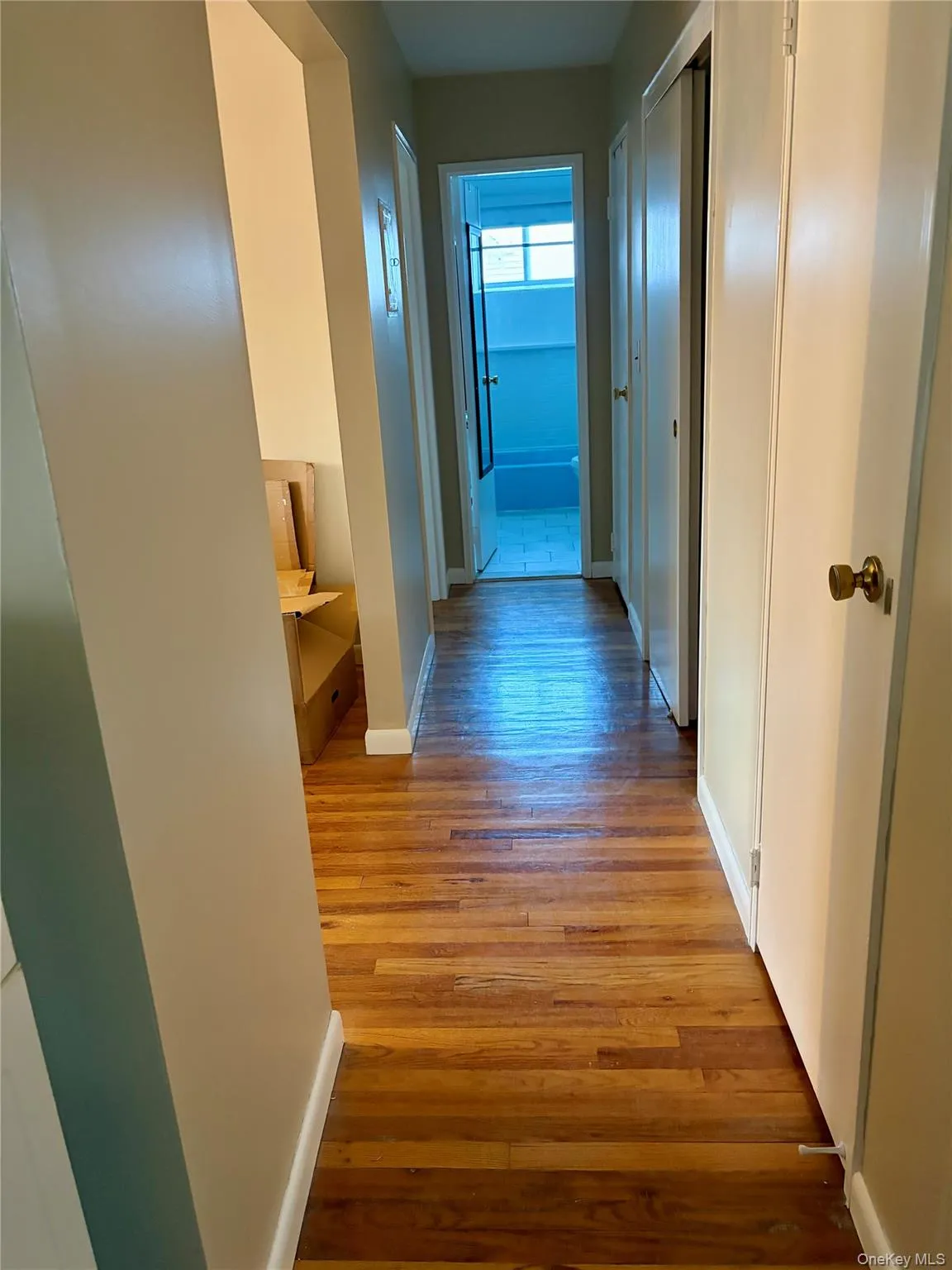 Corridor featuring baseboards and light wood finished floors Corridor featuring baseboards and light wood finished floors